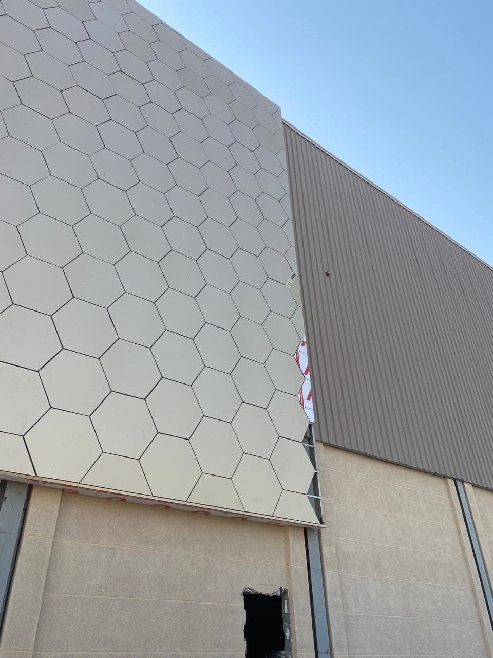Detail of the hexagonal facade panels meeting the roof sheeting